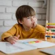 front-view-child-with-abacus-learning-from-laptop-home